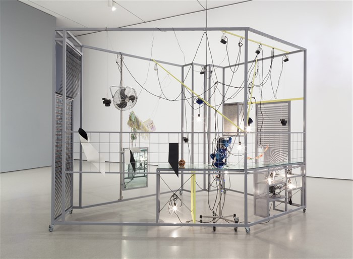 Haegue Yang. Sallim. 2009. Steel frame, perforated metal plate, caster, aluminum venetian blinds, knitting yarn, acrylic mirror, IV stand, light bulbs, cable, electric fan, timer, garlic, dishes, hot pad, and scent emitter. 8′ 2 1/2″ x 13′ 9 3/8″ x 10′ 2″ (250 x 420 x 310 cm). The Museum of Modern Art, New York. Fund for the Twenty-First Century and gift of Agnes Gund, Glenn Fuhrman, and Jerry I. Speyer. © 2023 Haegue Yang